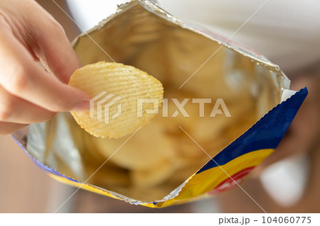 Hand hold potato chips with snack bag Hand hold potato chips with snack bag 104060775