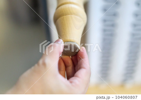 Woman sticking floor care pad at sofa leg Woman sticking floor care pad at sofa leg 104060807
