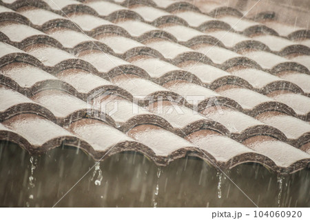 rain falling down from the house roof 104060920