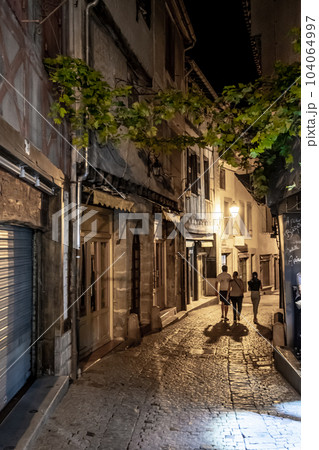 Narrow Alley With Illuminated Ancient Buildings In The Ancient Fortress Of Medieval City Carcassonne In The Night In Occitania, France 104064997