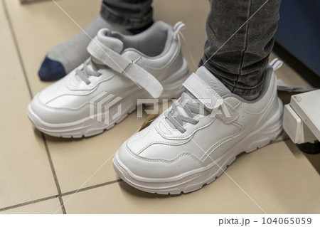 fitting new fashionable sneakers in a shoe store. Buying new shoes 104065059