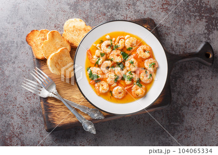 Spanish Garlic Shrimp with an ajillo sauce closeup on the plate. Horizontal top view 104065334