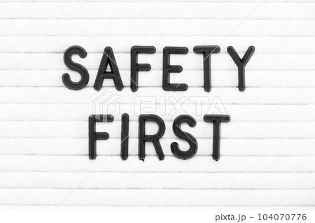 Black color letter in word safety first on white felt board background Black color letter in word safety first on white felt board background 104070776