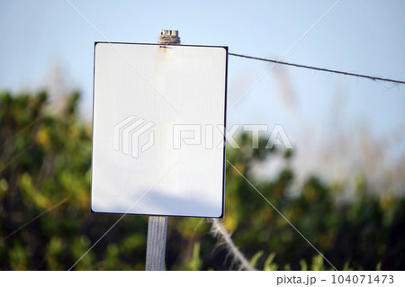 Empty signboard with copy space on seaside beach with small sand dunes and grassy vegetation on warm summer evening Empty signboard with copy space on seaside beach with small sand dunes and grassy vegetation on warm summer evening 104071473