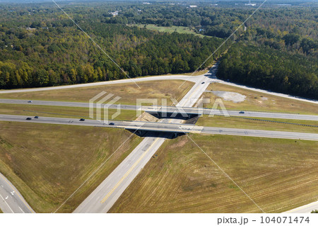 Elevated view of freeway exit junction over road lanes with fast moving traffic cars and trucks. Interstate transportation infrastructure in USA 104071474