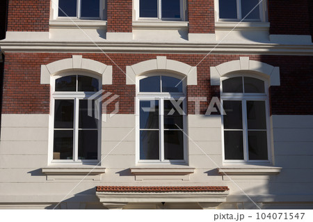 Front view of the curtain wall of the historic building with large windows. Front view of the curtain wall of the historic building with large windows. 104071547