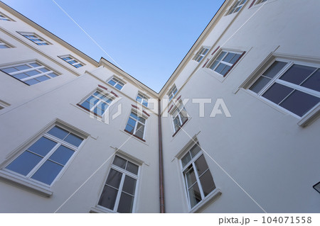 The smooth wall of the building with large windows seen from the very bottom. 104071558