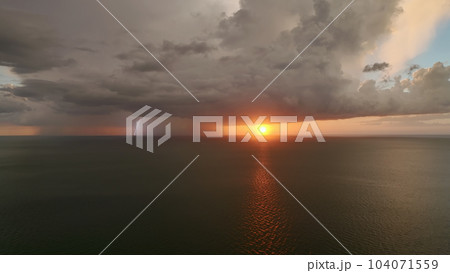 Dark weather front clouds forming on stormy sky during heavy rainfall season over sea water in summer evening Dark weather front clouds forming on stormy sky during heavy rainfall season over sea water in summer evening 104071559