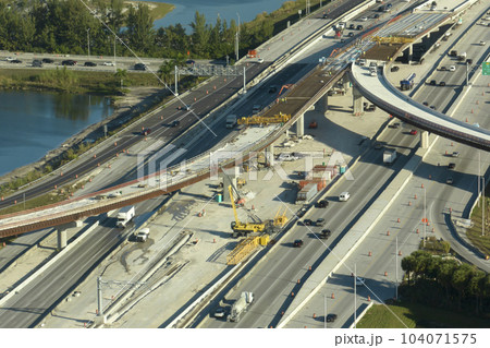 Construction roadworks on american transport infrastructure. Renovation of highway road interchange with moving traffic in Miami, Florida. Development of interstate transportation concept Construction roadworks on american transport infrastructure. Renovation of highway road interchange with moving traffic in Miami, Florida. Development of interstate transportation concept 104071575