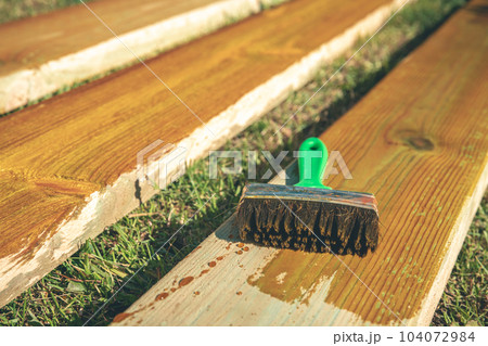 coating wooden boards with an antiseptic with a brush. construction coating wooden boards with an antiseptic with a brush. construction 104072984