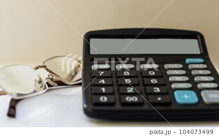 Glasses and calculator on white background, working desk of businessman Glasses and calculator on white background, working desk of businessman 104073499