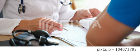 Cardiologist doctor examines and analyzes cardiogram and talks to patient in clinic Cardiologist doctor examines and analyzes cardiogram and talks to patient in clinic 104073795
