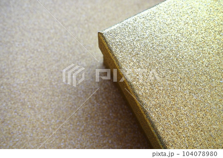 Golden gift box on a golden background. Decorative surprise box. Copy space. 104078980
