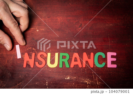 INSURANCE Concept. Colorful text from letters of the alphabet on a painted wooden background 104079001