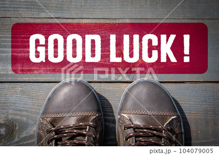 Good Luck. Motivation and inspiration concept. Street shoes on a wooden texture background Good Luck. Motivation and inspiration concept. Street shoes on a wooden texture background 104079005