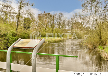 an open book on the edge of a body of water with trees and bushes in the background is blue sky 104079469