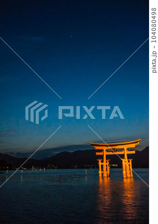広島 日没後の海に浮かぶ厳島神社の幻想的な鳥居 104080498