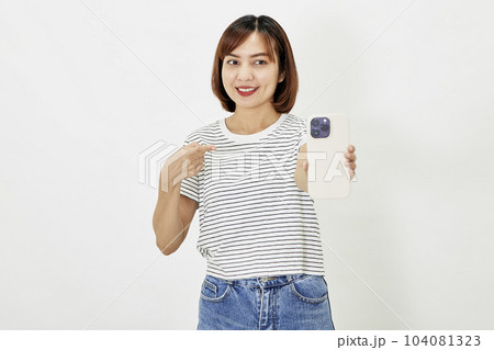 Young Asian female in t-shirt and blue jeans showing smartphone Young Asian female in t-shirt and blue jeans showing smartphone 104081323