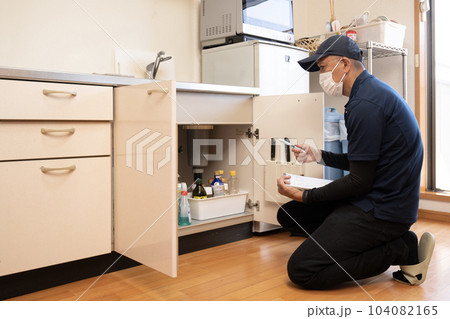 台所の片付けの見積もりをする男性作業員 台所の片付けの見積もりをする男性作業員 104082165