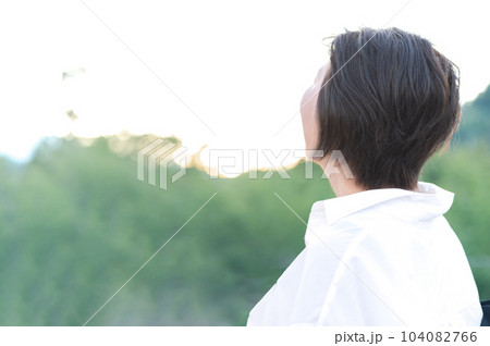 空を見上げる中年女性の後ろ姿 104082766