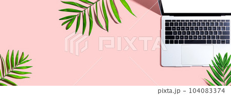Laptop computer with tropical leaves 104083374