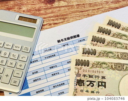 給与明細と現金・電卓 104083746