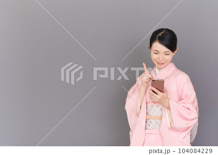スマートフォンを操作する着物を着た女性 スマートフォンを操作する着物を着た女性 104084229