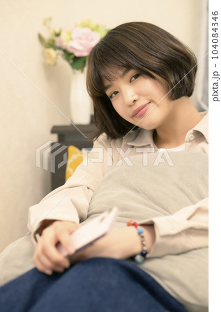 ベッドでスマホを見る若い女性 104084346