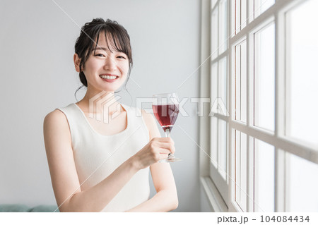 家で赤い飲み物を昼飲みするアジア人女性（赤ワイン・アセロラ・ザクロ・シソ・ポリフェノール・タンニン） 104084434