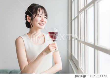 家で赤い飲み物を昼飲みするアジア人女性（赤ワイン・アセロラ・ザクロ・シソ・ポリフェノール・タンニン） 104084436