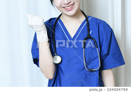 室内でガッツポーズをする医療従事者の女性 104084799