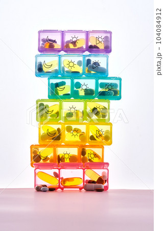 Bright pill box with different pills and vitamins. 104084912