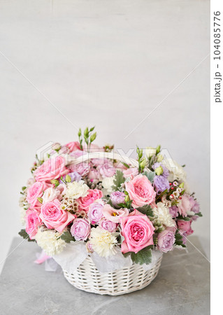 Flower arrangement in Wicker basket. Beautiful bouquet of mixed flowers on a marble table. Floral shop concept . Handsome fresh bouquet. Flowers delivery Flower arrangement in Wicker basket. Beautiful bouquet of mixed flowers on a marble table. Floral shop concept . Handsome fresh bouquet. Flowers delivery 104085776
