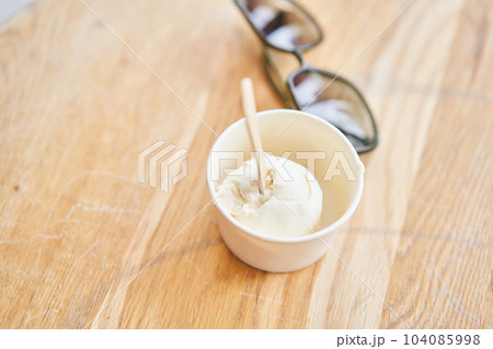 Vanilla ice-cream in disposable cups on the table. Italian gelateria. Natural fresh gelato. Vanilla ice-cream in disposable cups on the table. Italian gelateria. Natural fresh gelato. 104085998