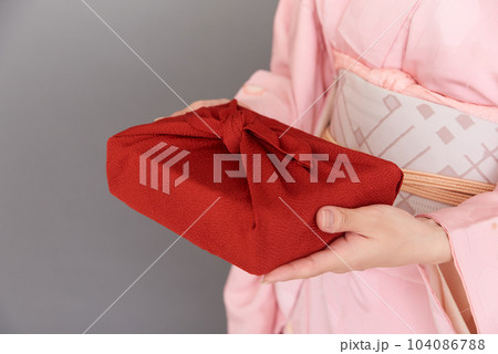 着物を着た女性が持つ風呂敷に包まれた贈り物 着物を着た女性が持つ風呂敷に包まれた贈り物 104086788