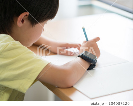 スマートウォッチを身につけて勉強している男の子 104087126