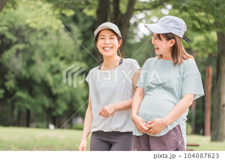 妊娠中に運動・ウォーキング・有酸素運動・散歩して話すプレママ・妊婦の女性・ママ友 妊娠中に運動・ウォーキング・有酸素運動・散歩して話すプレママ・妊婦の女性・ママ友 104087623