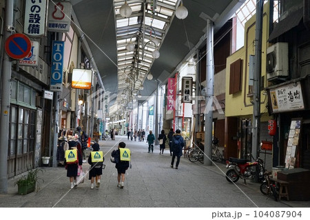 尾道の商店街と並んで歩く小学生 104087904