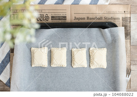 オーブンの天板に並べられた焼く前の一口パイ オーブンの天板に並べられた焼く前の一口パイ 104088022