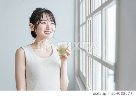 家でグリーンスムージーを飲む笑顔のアジア人女性 家でグリーンスムージーを飲む笑顔のアジア人女性 104088377