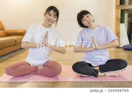 ヨガインストラクターの女性と小学生の女の子　キッズヨガ　小学生クラスイメージ 104089769