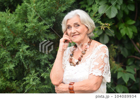 Portrait of happy senior woman smiling in autumn park Portrait of happy senior woman smiling in autumn park 104089934