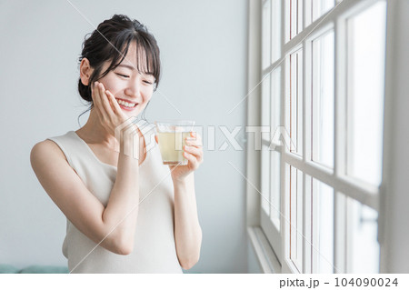家で朝コラーゲン・プラセンタ・ビタミンC配合の美容ドリンク・美容ジュースを飲むアジア人女性 104090024