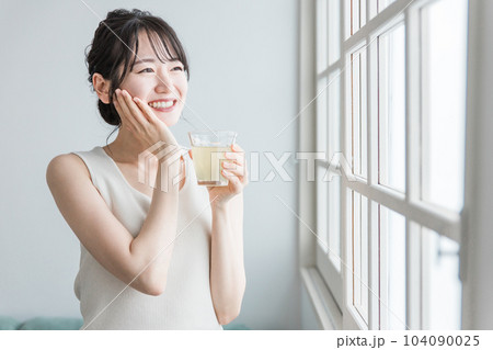家で朝コラーゲン・プラセンタ・ビタミンC配合の美容ドリンク・美容ジュースを飲むアジア人女性 104090025