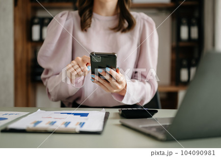 Business woman sitting front tablet ,laptop computer with financial graphs and statistics on monitor.at modern office Business woman sitting front tablet ,laptop computer with financial graphs and statistics on monitor.at modern office 104090981