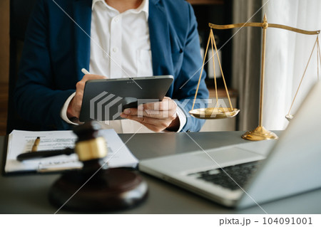 justice and law concept.Male judge in a courtroom  the gavel, working with smart phone and laptop and digital tablet computer on black table. 104091001