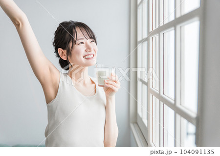 家で朝ミルク・牛乳を飲むアジア人女性 家で朝ミルク・牛乳を飲むアジア人女性 104091135