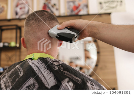 Rear view shot of hairdresser cutting hair of male client. Barber shop Rear view shot of hairdresser cutting hair of male client. Barber shop 104091801