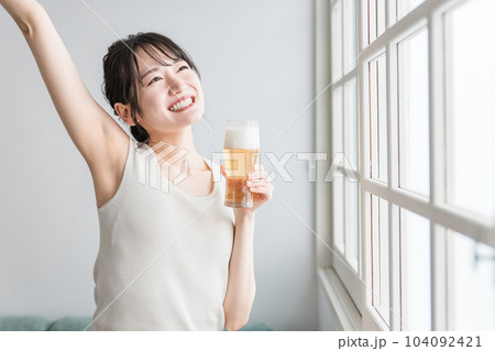 家でビールを昼飲みするアジア人女性（ビールグラス） 104092421