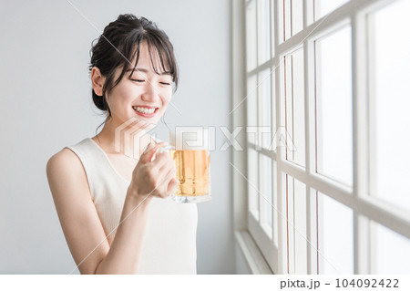 家でビールを昼飲みするアジア人女性（ビールジョッキ） 104092422
